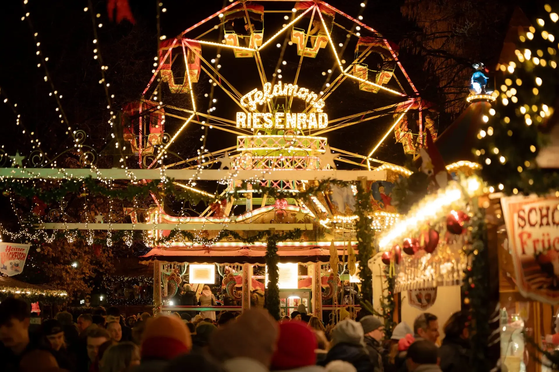 Beleuchtetes Riesenrad und Marktbuden auf dem Weihnachtsmarkt in Bielefeld
