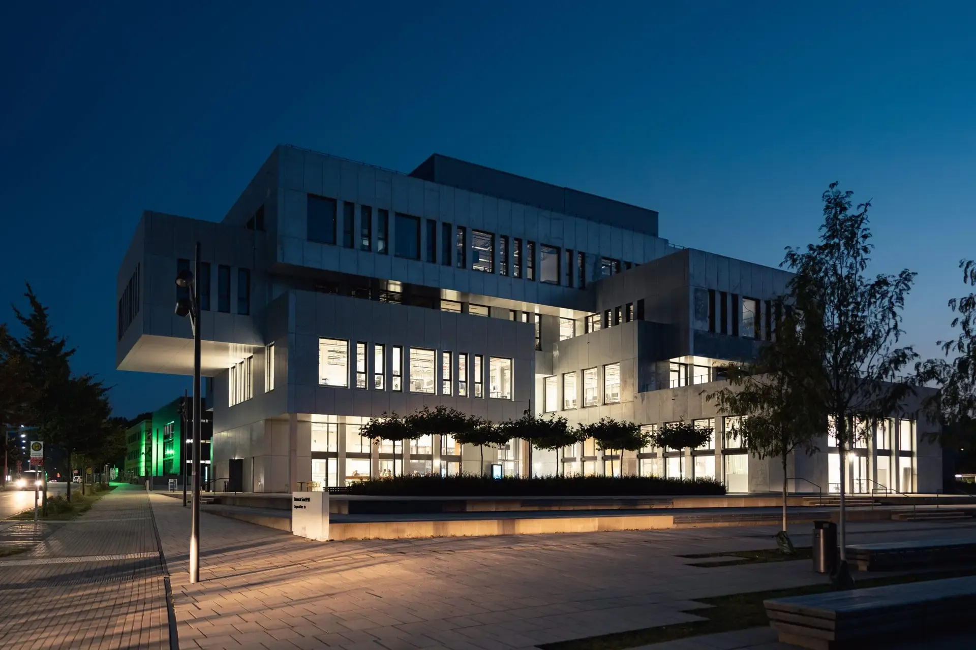 Beleuchtetes Hochschulgebäude in der Abenddämmerung, Architekturaufnahme
