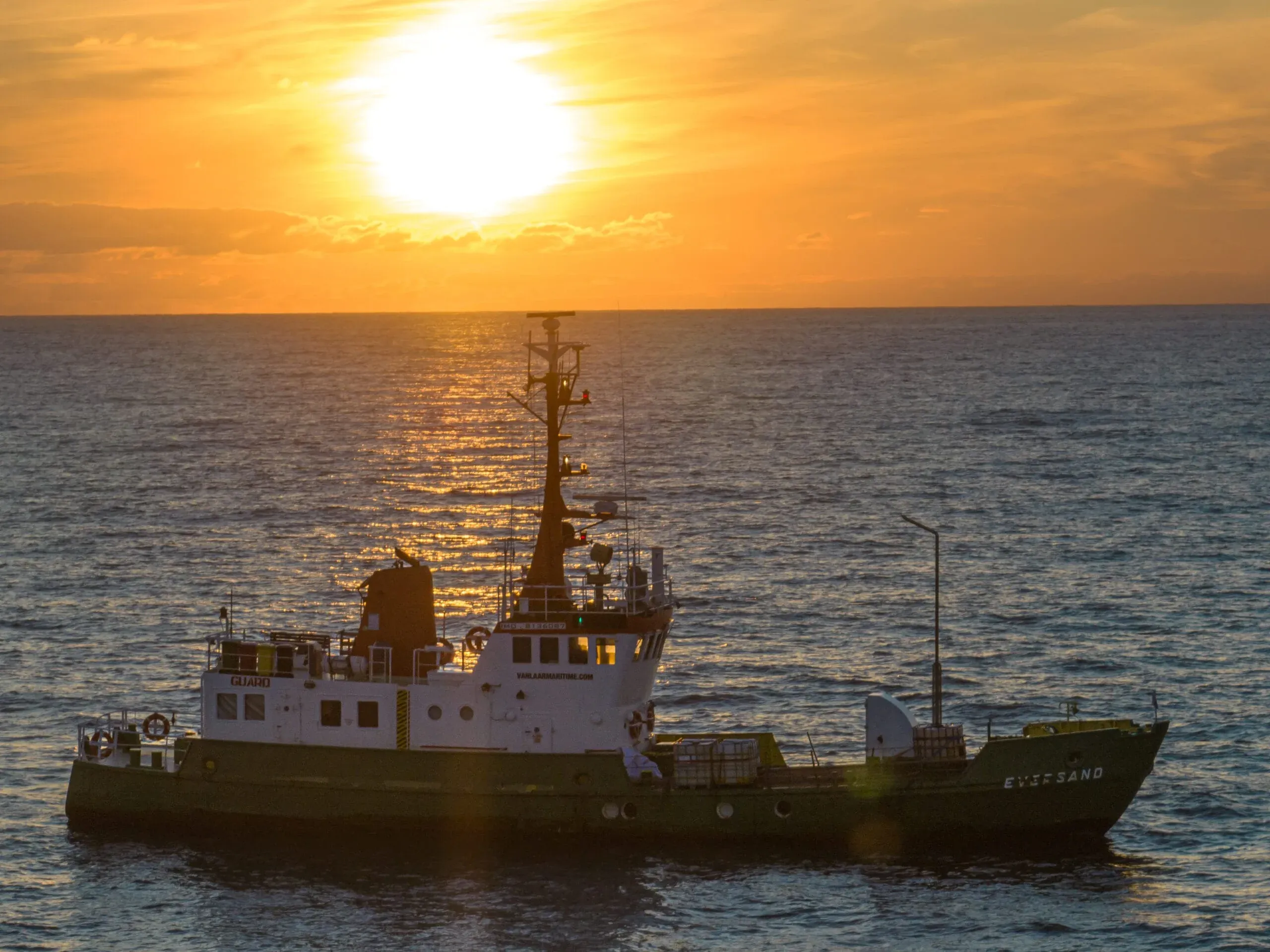 Drohnenaufnahme eines Schiffes auf See im Sonnenuntergang