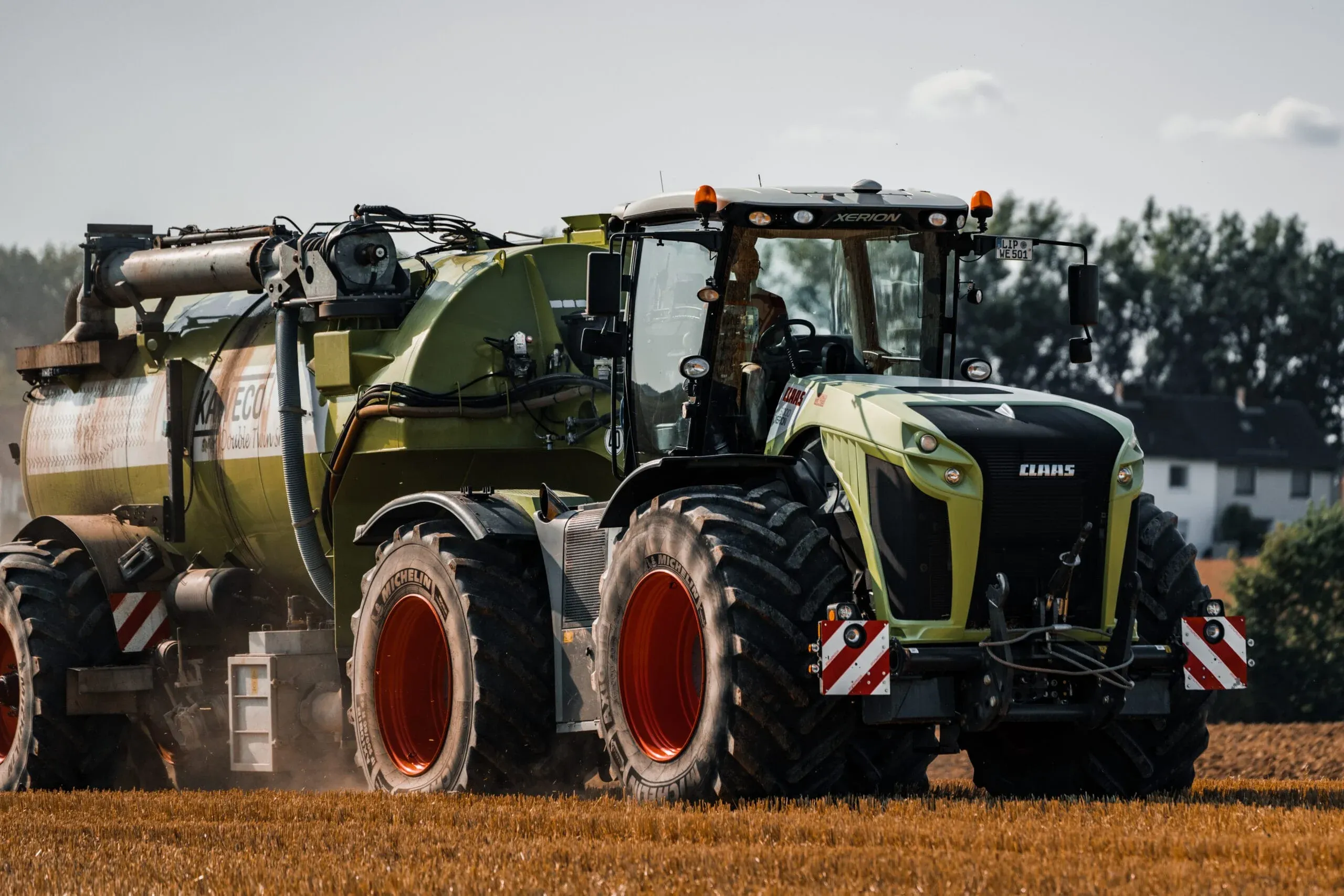 Zwei CLAAS Landmaschinen mit Güllefass bei der Feldarbeit
