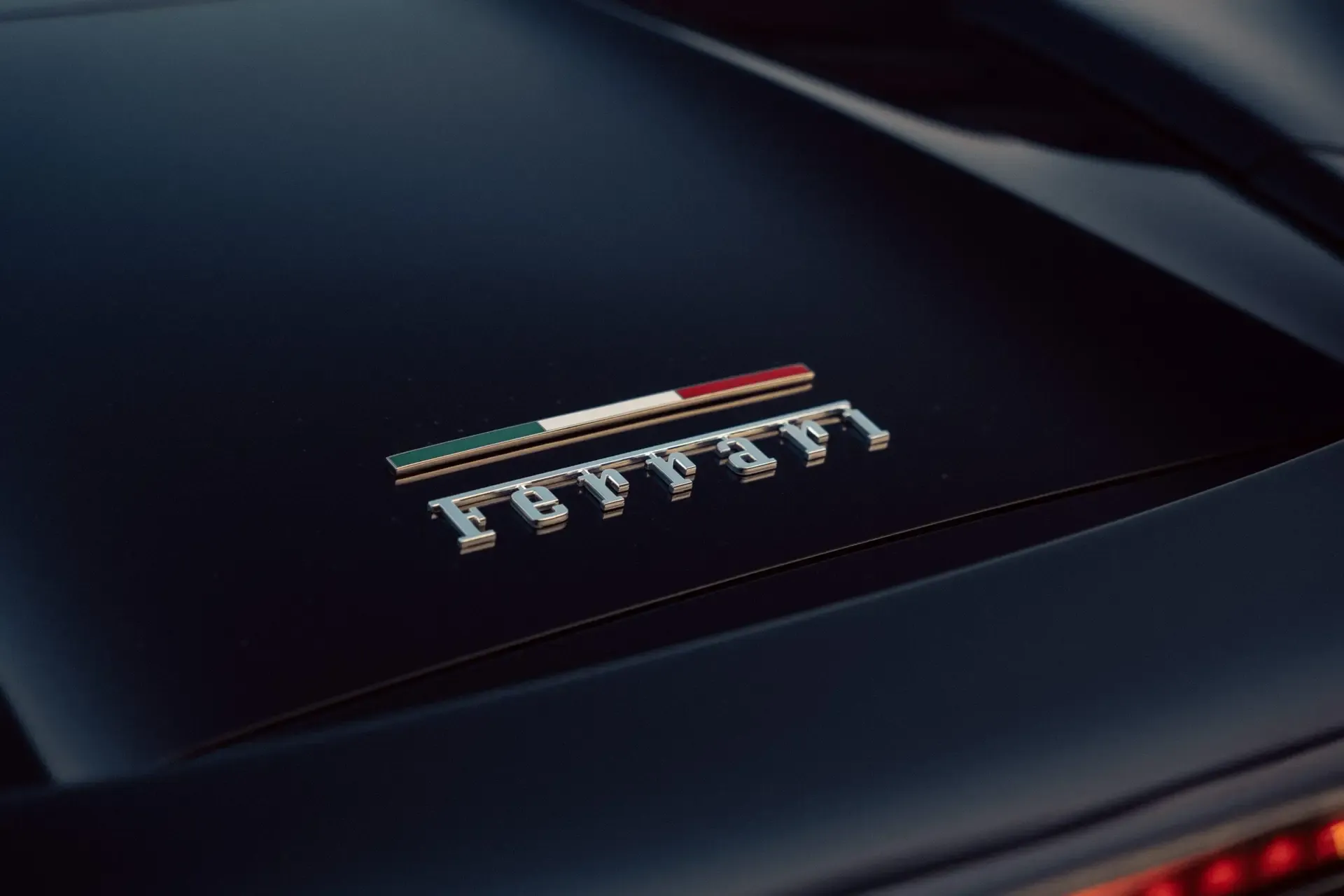 Ferrari-Emblem in Nahaufnahme auf dunklem Karosserielack