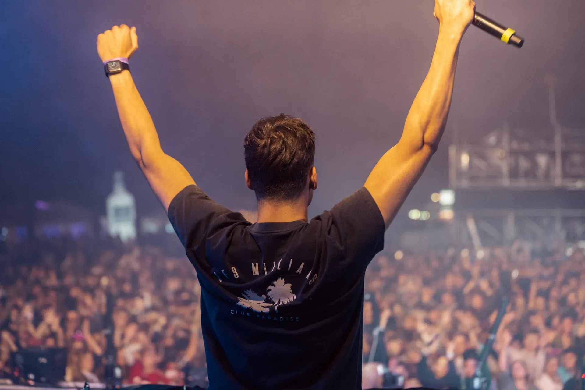 Künstler reißt auf der Bühne die Arme hoch, davor das Publikum des Lippe Open Air 2023