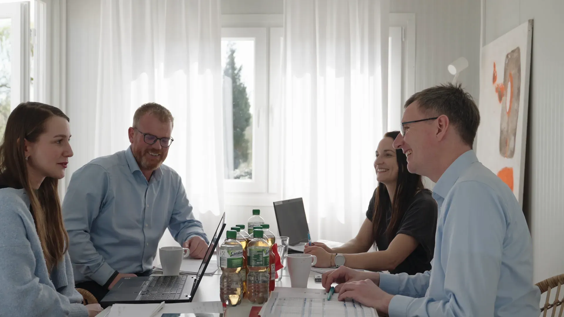 Szene aus dem Imagefilm für das Kulturstellwerk Nordlippe: vier Kolleginnen und Kollegen lachen bei der Teambesprechung